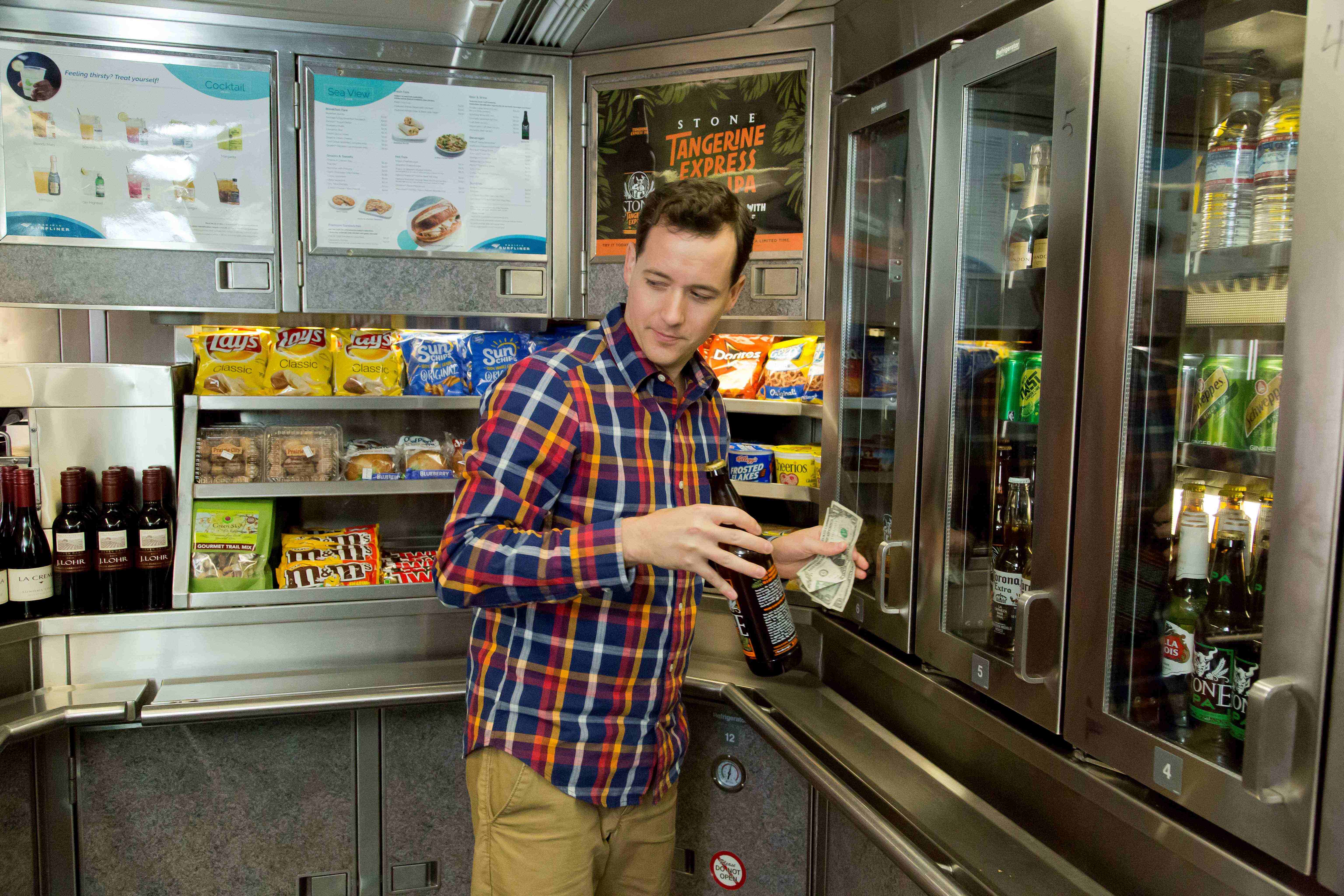 A man takes a beer from a beverage cooler in the Pacific Surfliner’s onboard Market Café Car.