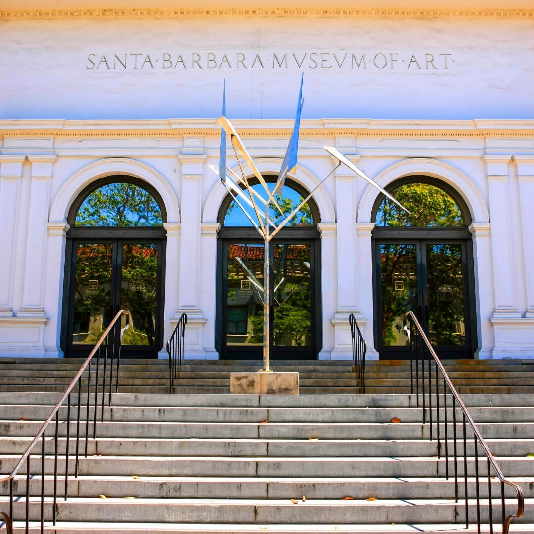 The front steps of the Santa Barbara Museum of Art, with arched window doorways and a pointy sculpture in front of them